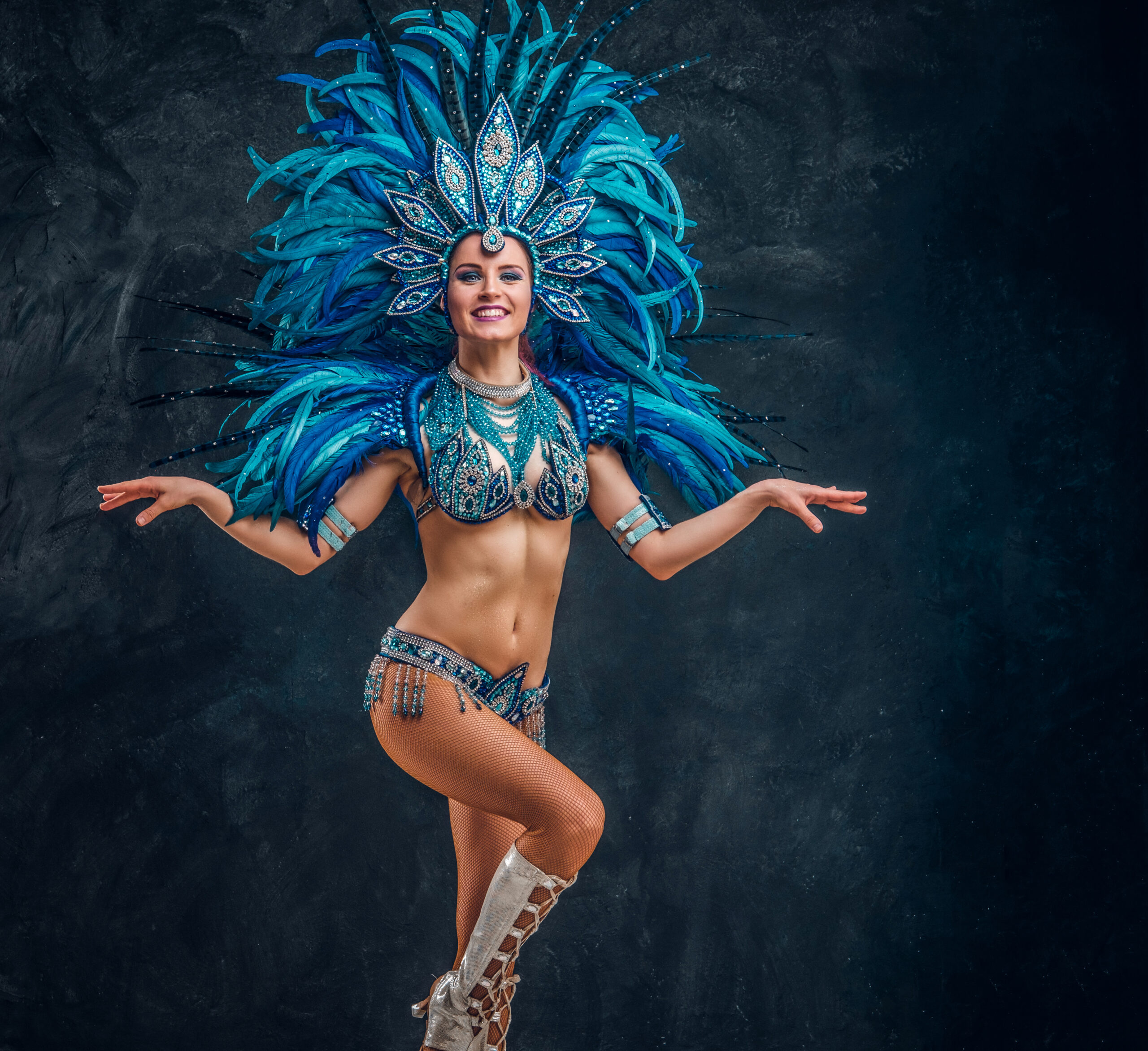 Happy brasil dancer is posing for photographer. She is wearing blue feather costume.